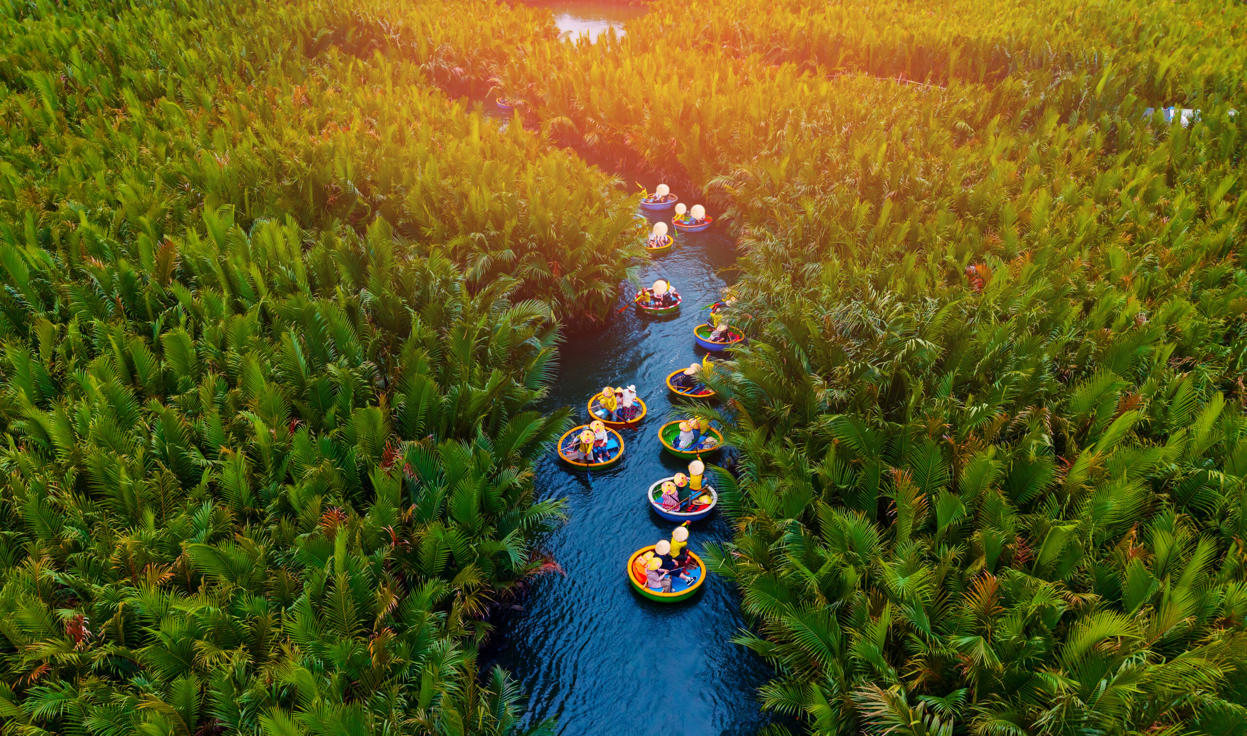 Scenic aerial view of round boats in hoi an waterways surrounded by lush greenery, travel banner for Vietnam